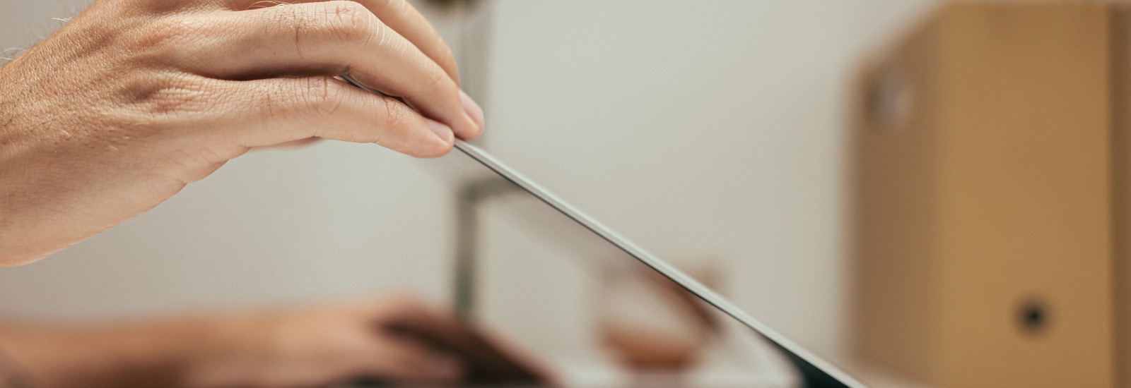 A hand closing a laptop at the end of the working day